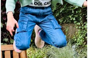 Kind trägt LOU Cargo Jeans beim Springen - bewegungsfreundliche Kindermode Himmelsfaden