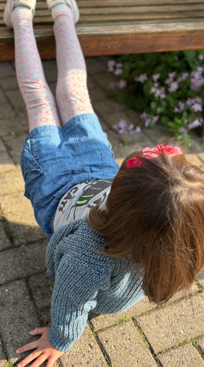 Kind in LOUCA Denim Cargo Rock entspannt auf Bank - komfortable Kindermode für den Alltag